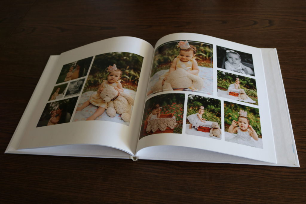 An open photo album showing various photos of a baby girl