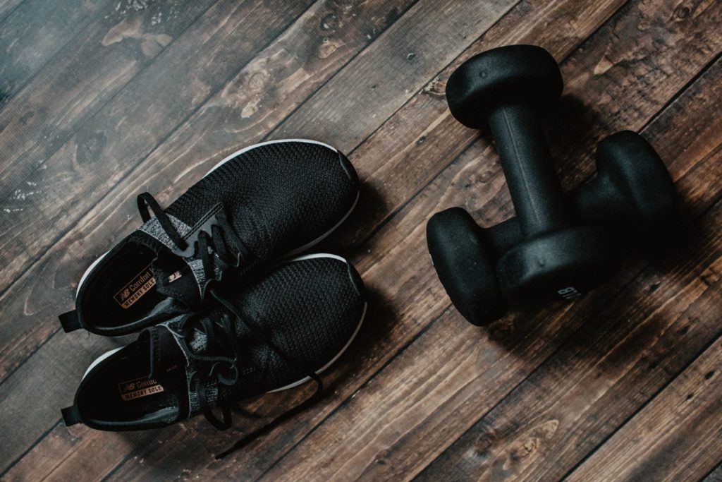 Black sneakers and a set of black dumbbells